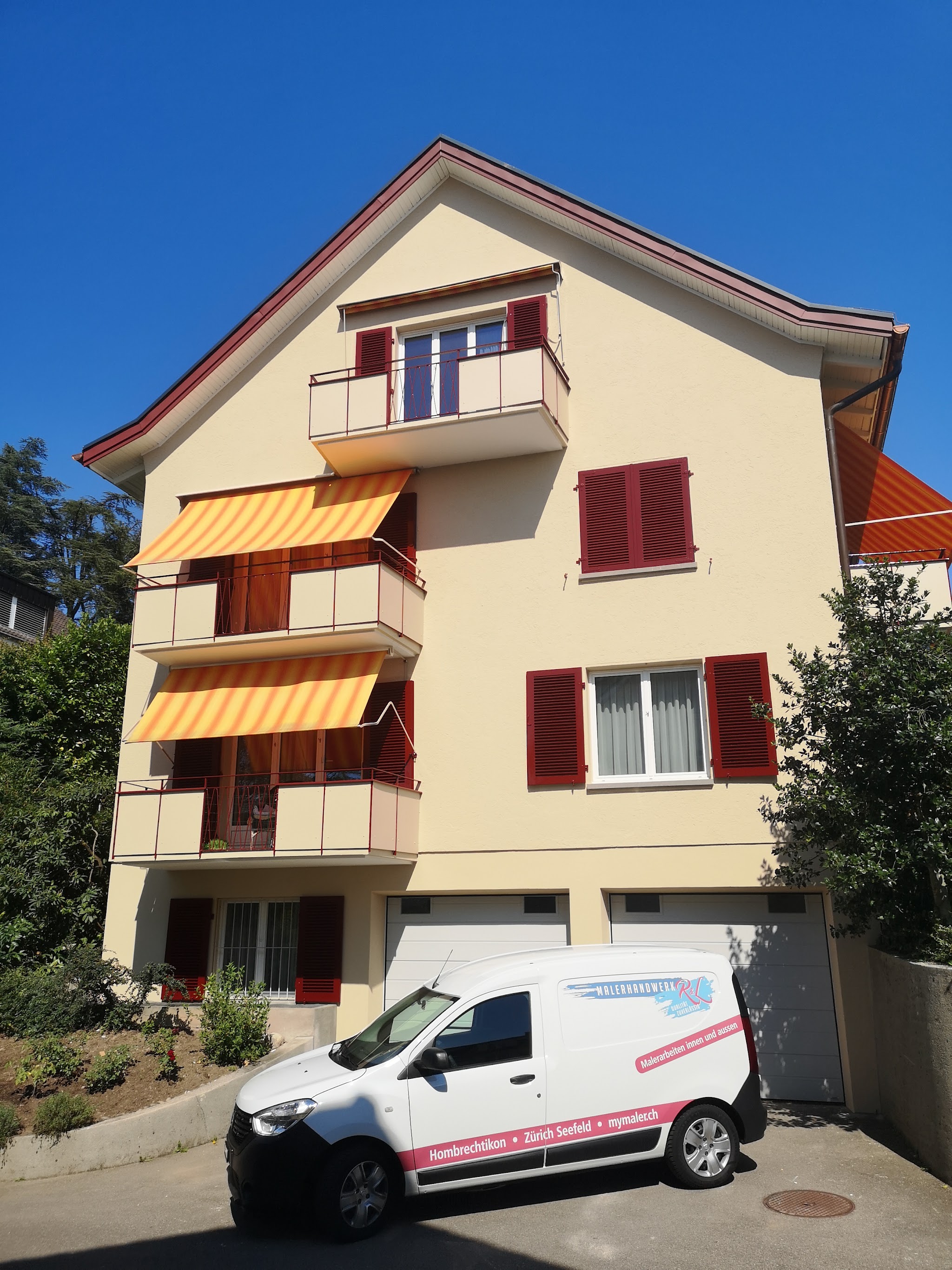 Frisch gestrichenes Haus mit roten Fensterläden und dem Lieferwagen von Malerhandwerk R&L davor